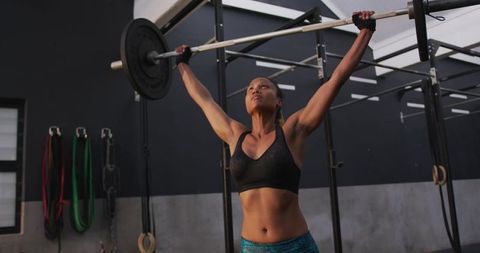 Strong Woman Intense Workout Lifting Barbell in Gym