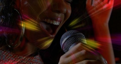 Energetic singer performing in dynamic karaoke lights
