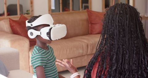 Young Black Girl Exploring Virtual Reality with Caregiver Guiding in Cozy Living Room