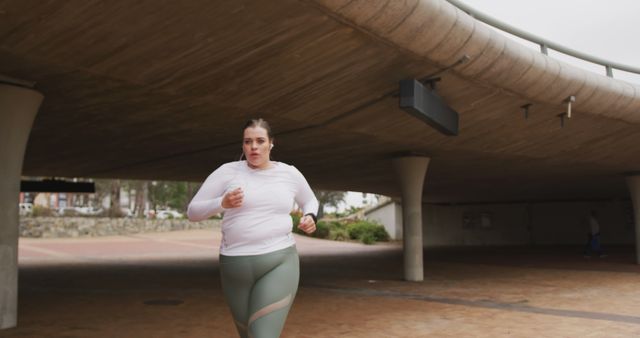 Young Woman Jogging Under Overpass in City Park - Download Free Stock Images Pikwizard.com