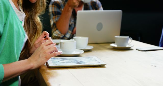 Woman using digital tablet while having coffee in cafeteria 