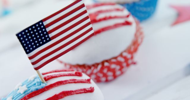 Cupcakes decorated in red, white, and blue icing topped with an American flag, symbolizing patriotic celebration, with copy space. These treats are often seen at events like Independence Day parties or Memorial Day gatherings.