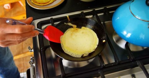 Home Cook Making Pancakes on Stove in Kitchen Environment