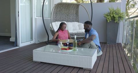 Romantic Gift Exchange on Balcony with Drinks and Snacks