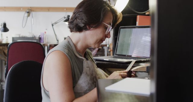 Female artisan concentrating on her work at a well-equipped workshop. Ideal for websites or articles on craftsmanship, art, DIY projects, hobby activities, or gender diversity in skilled trades.