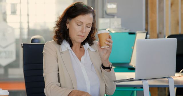 Tired Mature Businesswoman Working at Desk Holding Coffee Cup - Download Free Stock Images Pikwizard.com