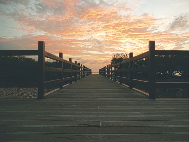 Wooden Boardwalk Leading To Scenic Sunset Over Water - Download Free Stock Photos Pikwizard.com