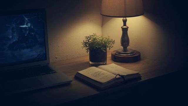 Cozy Home Office Desk with Lamp, Notebook, and Laptop