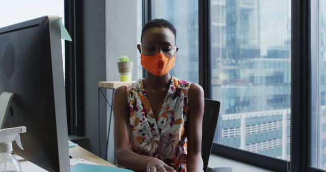 Businesswoman Wearing Face Mask Working on Computer in Office - Download Free Stock Images Pikwizard.com