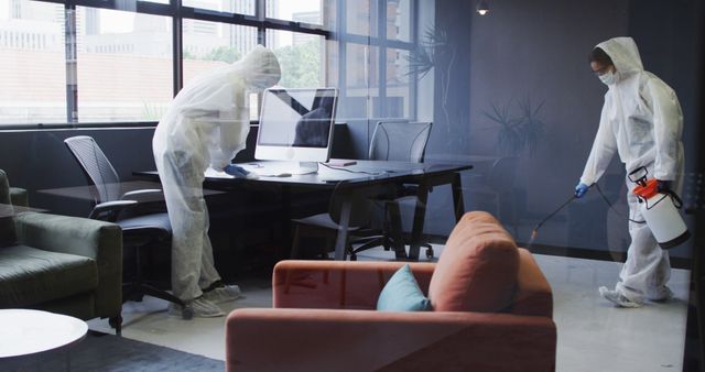 Cleaners wearing protective clothes sanitizing modern office space. hygiene in business workplace during covid 19 coronavirus pandemic.