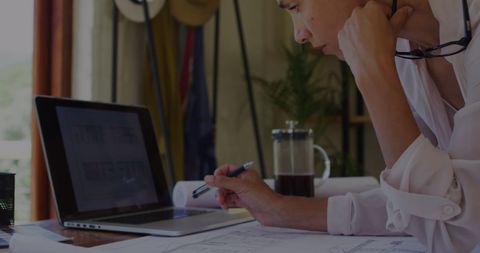Biracial Woman Analyzing Documents in Home Office Setting