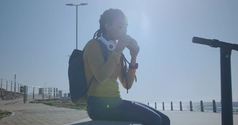 Woman with Headphones Observing Horizon on Promenade