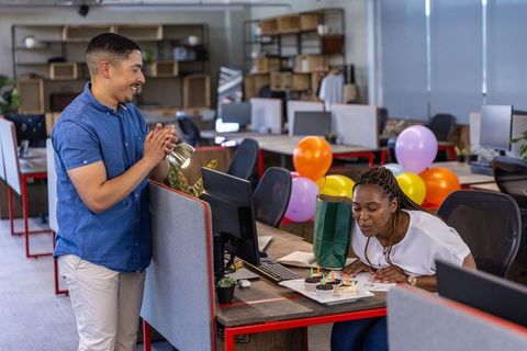 Coworkers Celebrating Birthday with Cupcakes and Balloons at Desk