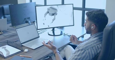 Engineer Designing Robotic Gripper in Modern Office Environment