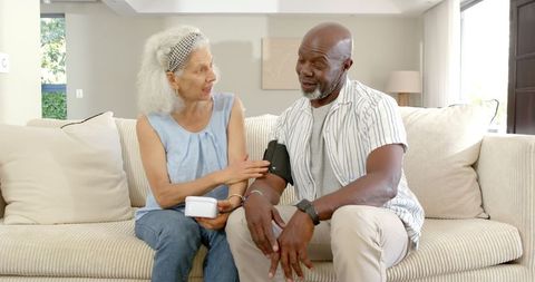 Elderly Couple Using Digital Blood Pressure Monitor at Home