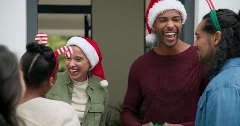 Joyful friends wearing santa hats sharing laughter