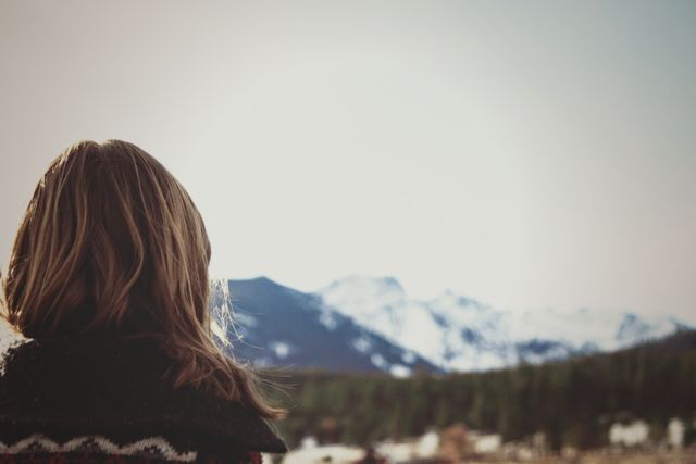 Woman admiring scenic snowy mountains on a bright day - Download Free Stock Images Pikwizard.com