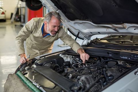 Experienced Mechanic Examining Car Engine in Auto Repair Workshop