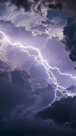 Arcing lightning bolt branching through towering cumulonimbus clouds vertical night video