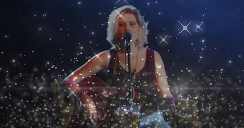 Teen singer performing acoustic guitar under spotlight with sparkling bokeh lights