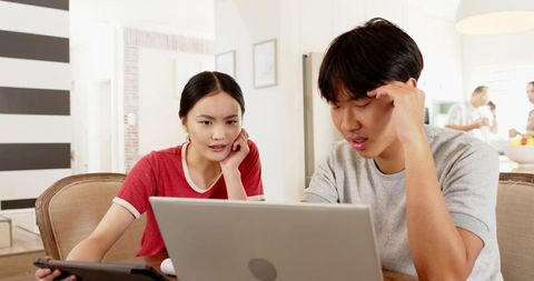 Focused Young Adults Studying on Laptop in Bright Home