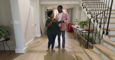 Couple relaxing and conversing in modern home hallway
