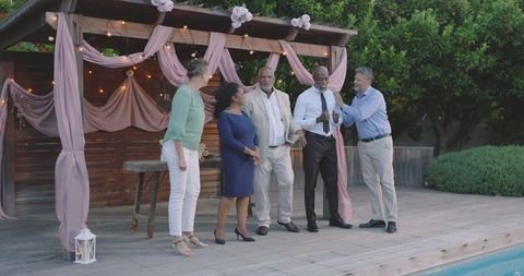 Senior Friends Celebrating Trusty Friendship by Pool at Charming Garden Wedding