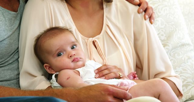 Close-Up of Baby in Mother's Arms with Father Offering Support - Download Free Stock Images Pikwizard.com