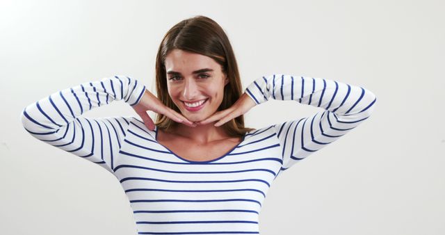 Smiling Woman with Hands Framing Face in Striped Shirt - Download Free Stock Images Pikwizard.com