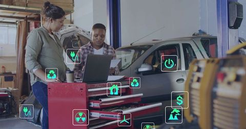 Mechanics reviewing documents in modern garage with energy icons overlay