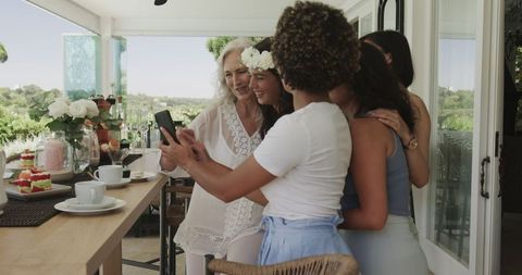 Smiling Women Taking Selfie at Outdoor Wedding Reception