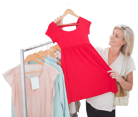 Woman shopping for clothing, holding up red dress, seen at boutique