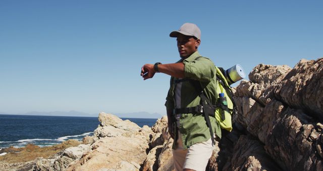 African american man hiking in countryside by the coast. fitness training and healthy outdoor lifestyle.