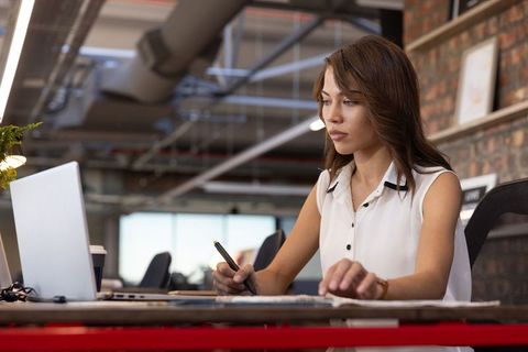 Creative professional woman using stylus in modern office