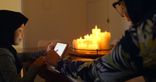 Mother and Daughter Using Tablet in Candlelit Room - Download Free Stock Images Pikwizard.com