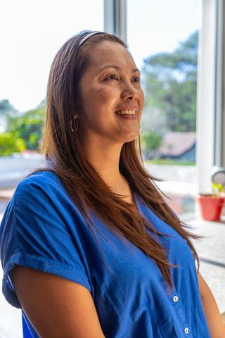 Mature Woman Gazing Out Window in Natural Home Setting