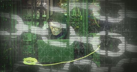 Asian male hacker in dimly lit server room with digital overlay