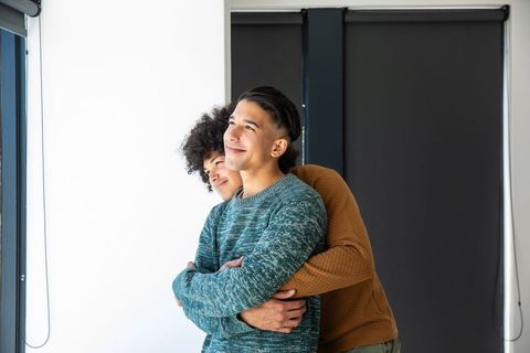 Lovingly embracing male partners in modern apartment setting
