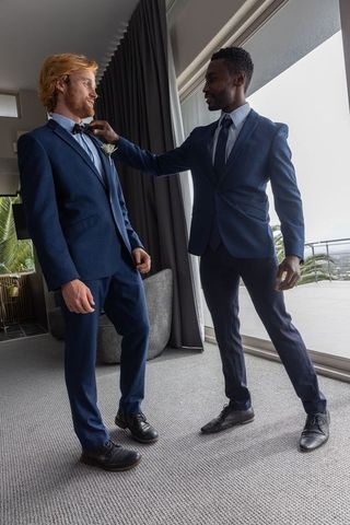 Friends preparing for wedding adjusting formal attire