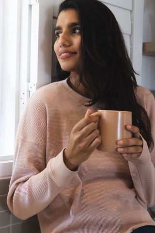 Woman relaxing with coffee in cozy kitchen setting