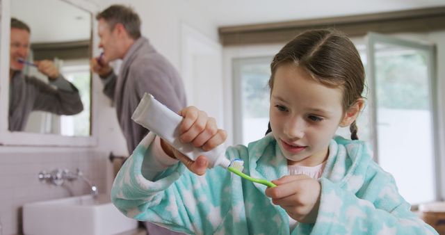 Young Girl Preparing to Brush Teeth with Father in Background - Download Free Stock Images Pikwizard.com