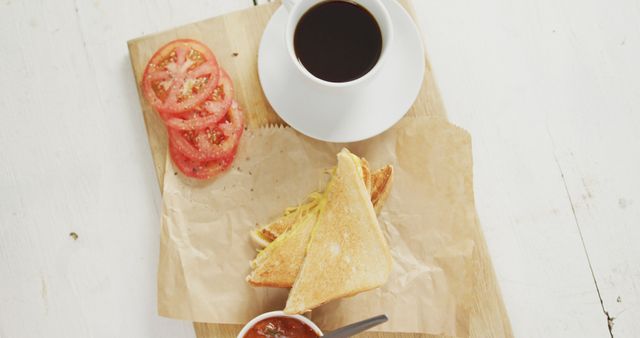 Image of coffee, freshly prepared cheese white bread sandwich with tomatoes on paper and white plate. fusion food, breakfast and home made snack concept.