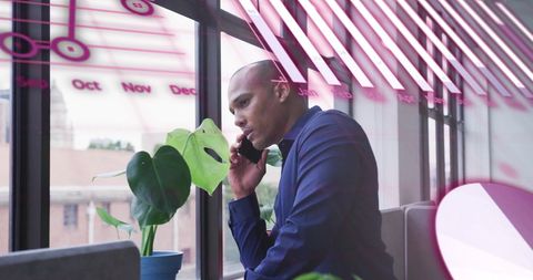 Businessman Analyzing Financial Data by Window in Office