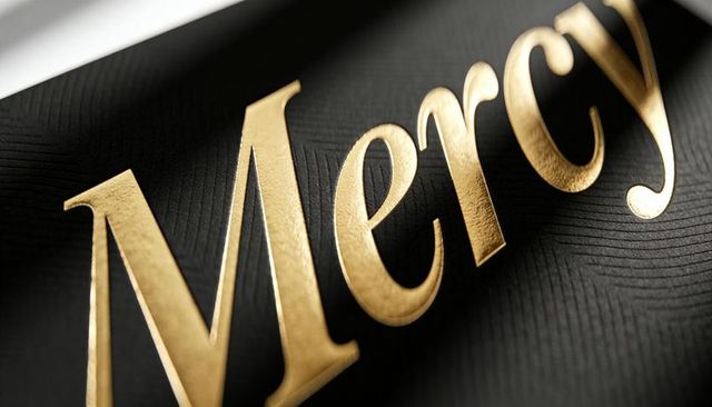 Gold foil mercy lettering on black textured cover featuring embossed edges luxury macro