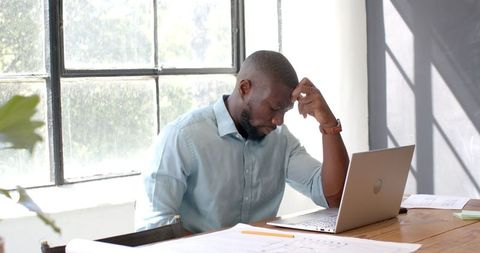 Architect Examining Project Plans on Laptop in Sunlit Office - Download Free Stock Images Pikwizard.com