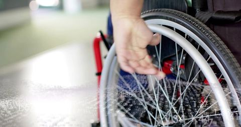 Woman pushing wheelchair through corridor showing accessibility, mobility and independence