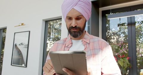 Man in Traditional Turban Using Tablet for Digital Work