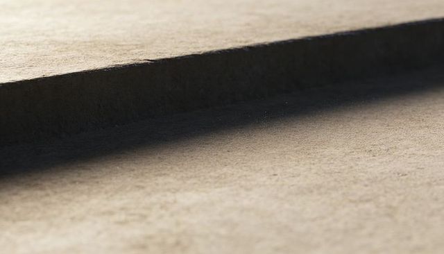 Macro raised ledge casting soft shadow on beige fibrous surface, minimal abstract texture