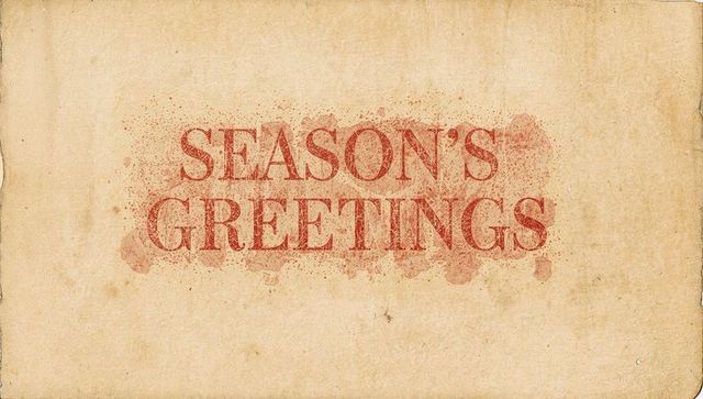 Vintage season's greetings typography on aged parchment with distressed ink splatter