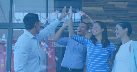 Team Celebrating Success with High Five in Modern Open-Plan Office